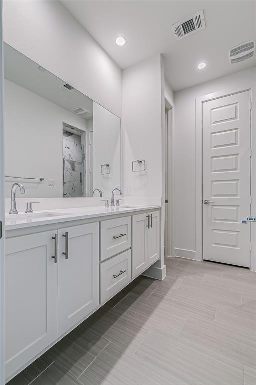 6028 Lewis Street, Unit 204 Dallas, TX 75206 - Photo 33 of 39 a spacious bathroom with a double vanity sink a mirror and a