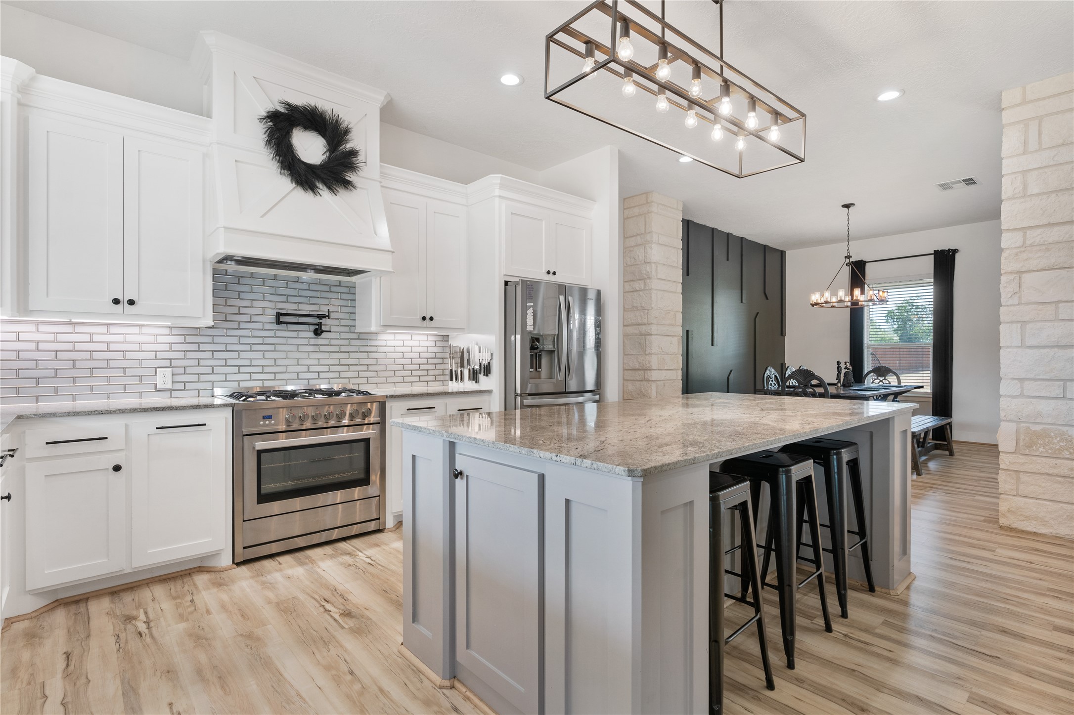 41111 Community Road Magnolia, TX 77354 - Photo 11 of 49 a kitchen with a stove kitchen island stainless steel appliances cabinets and wooden floor