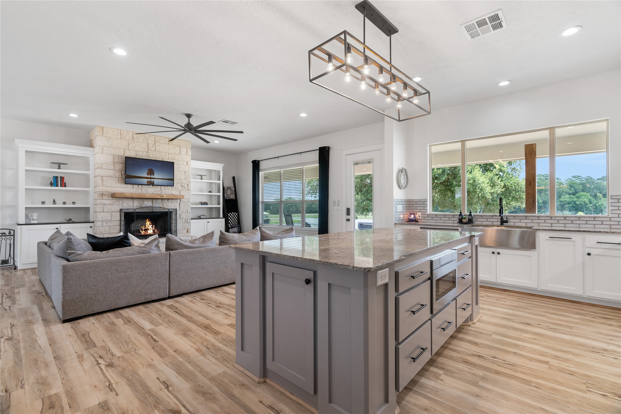 41111 Community Road Magnolia, TX 77354 - Photo 12 of 49 a kitchen with kitchen island granite countertop a stove top oven a sink dishwasher a dining table and chairs with wooden floor