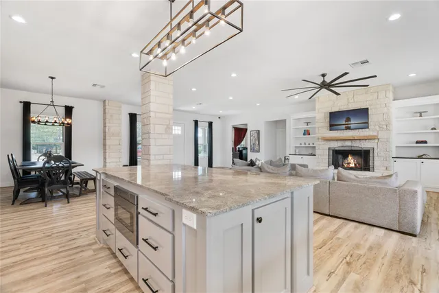 a kitchen with stainless steel appliances granite countertop a sink a stove and a wooden floors