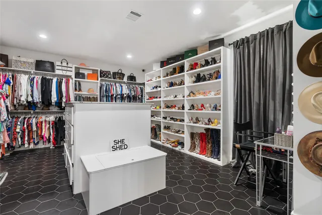 a view of walk in closet with clothes and shoes