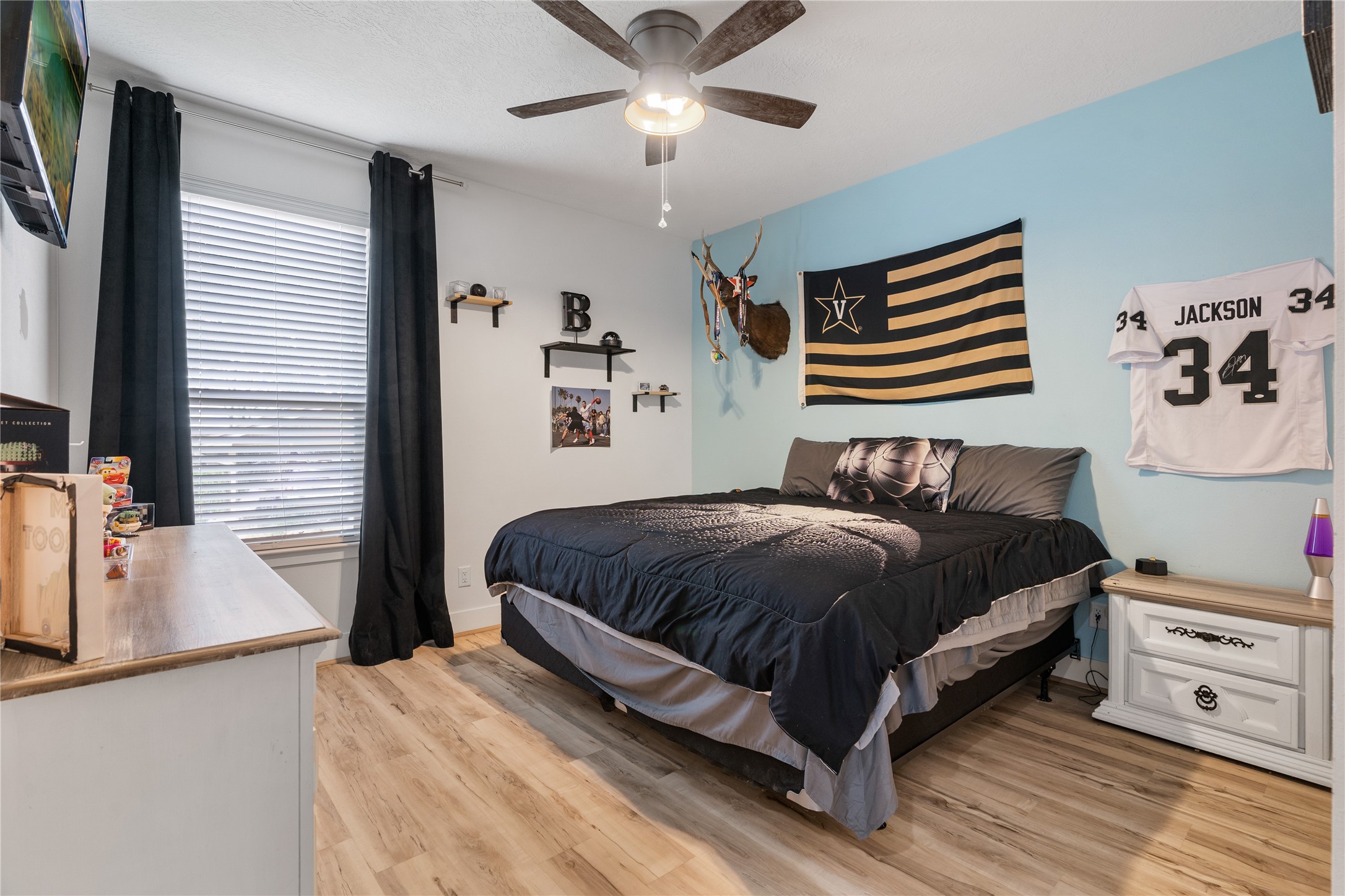 41111 Community Road Magnolia, TX 77354 - Photo 21 of 49 a bedroom with a bed and a flat tv screen on dresser