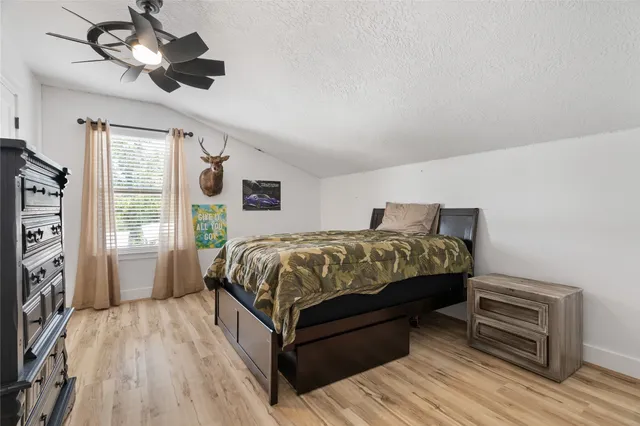 a bedroom with a bed wooden floor and window