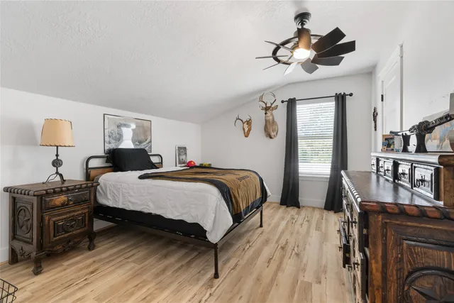 a bedroom with a bed a dresser and book shelfs