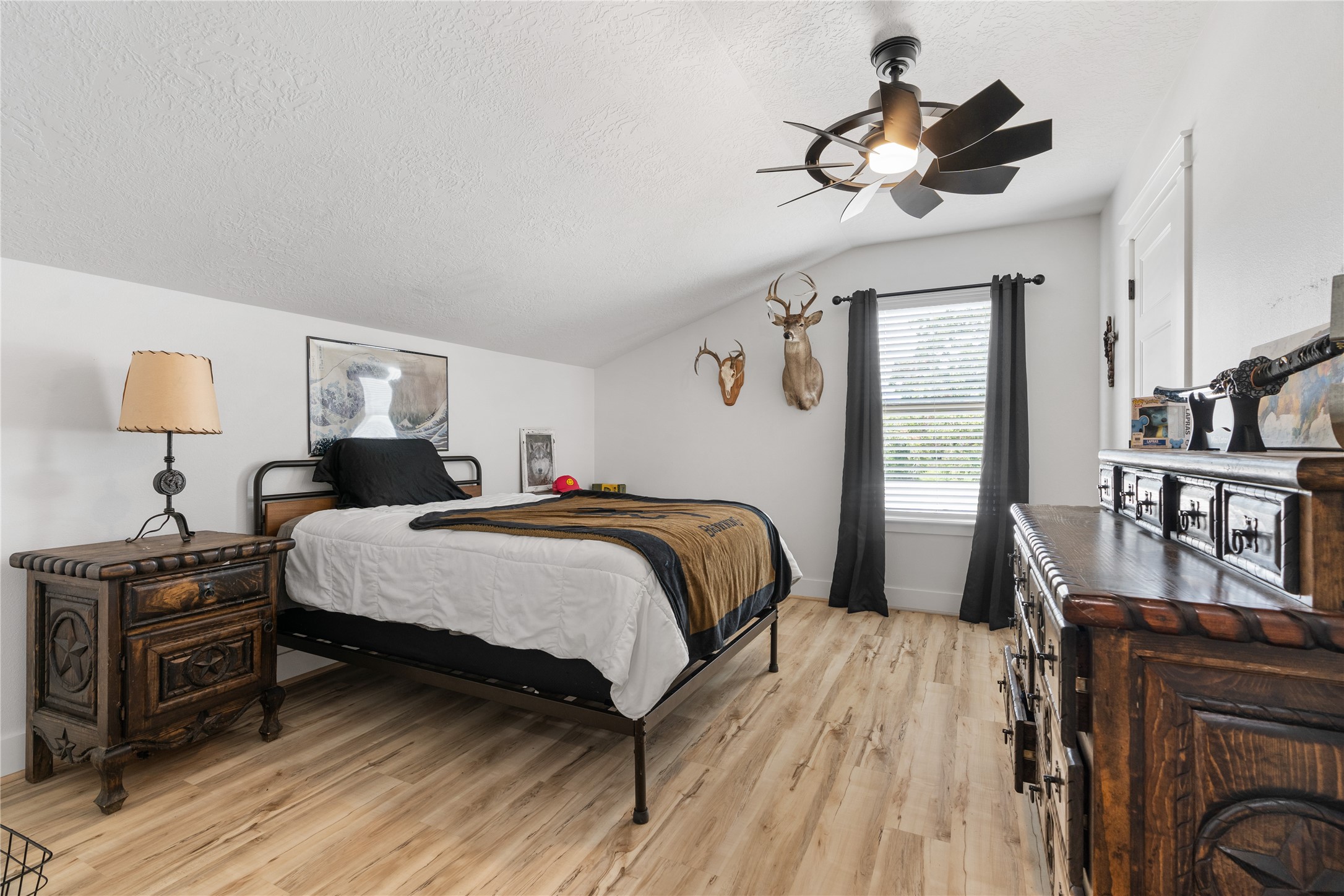 41111 Community Road Magnolia, TX 77354 - Photo 28 of 49 a bedroom with a bed a dresser and book shelfs