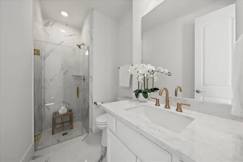 a bathroom with a granite countertop sink a toilet and a mirror