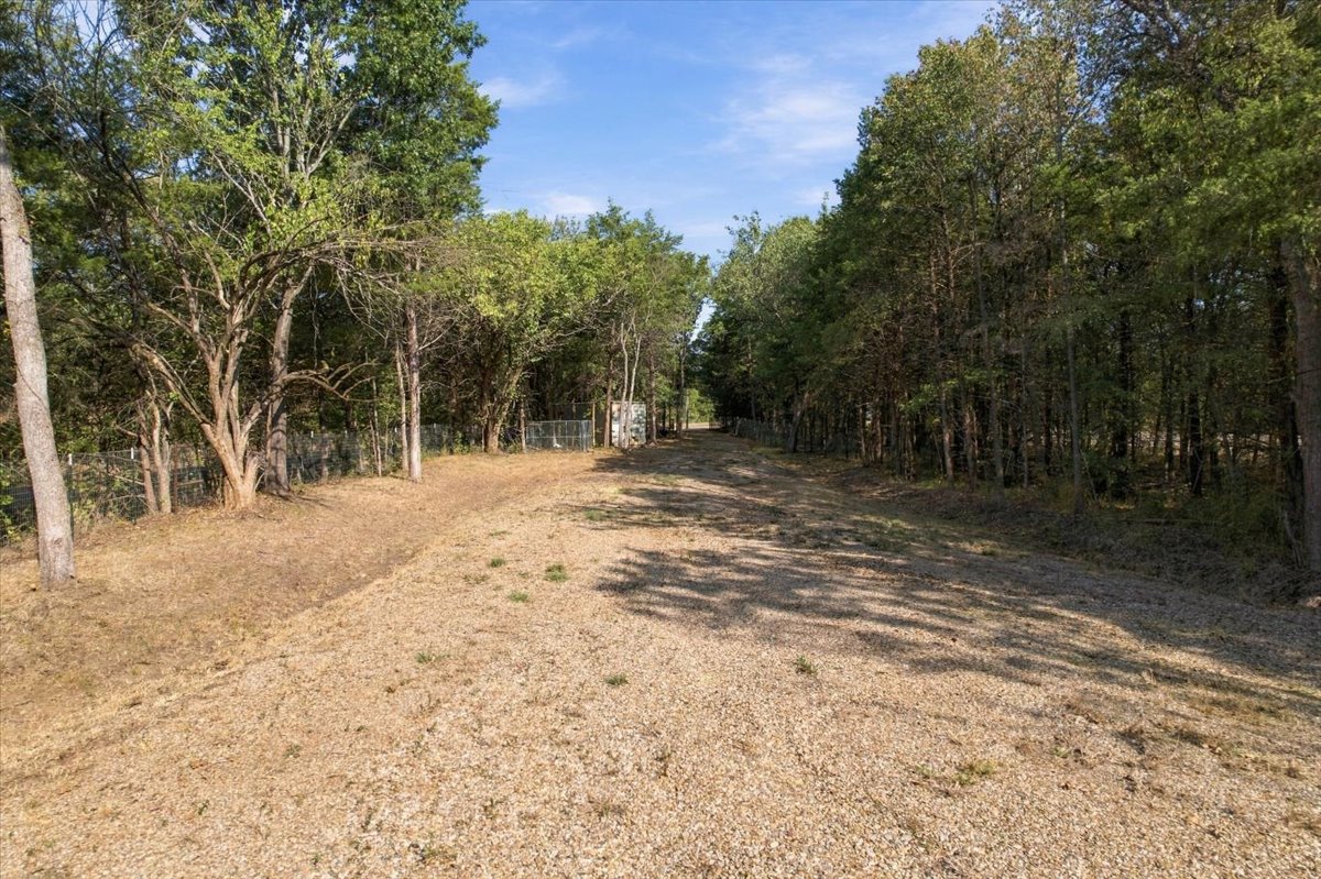Bloomfield Road Colbert, OK 74733 - Photo 19 of 25 Gravel driveway flanked by mature trees and fencing