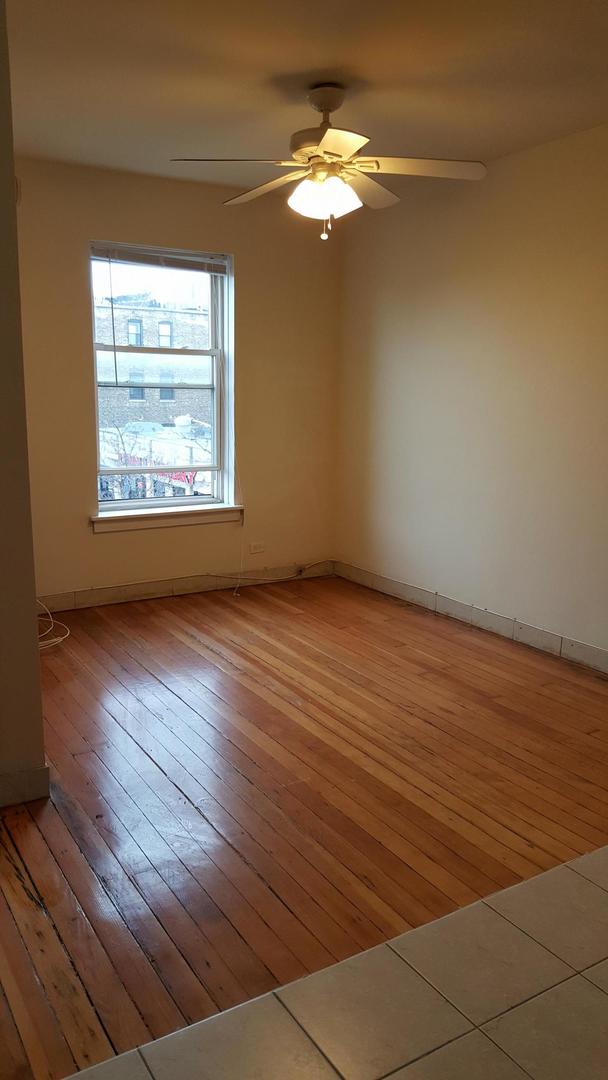 4764 North Virginia Avenue, Unit 206 Chicago, IL 60625 - Photo 5 of 16 an empty room with wooden floor and windows