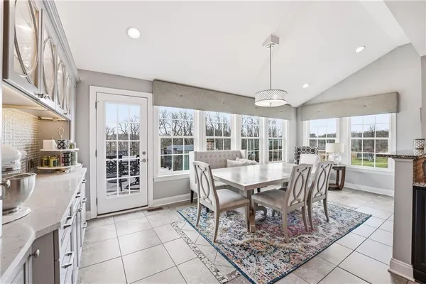 a dining room with furniture a chandelier and wooden floor