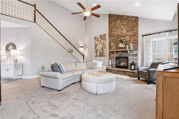 a living room with furniture a fireplace and a large window
