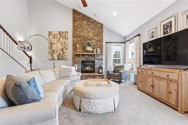 a living room with furniture a flat screen tv and a fireplace