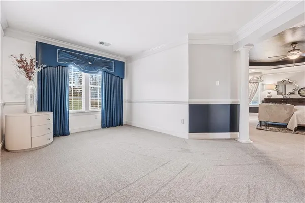 a view of an empty room with kitchen and a window