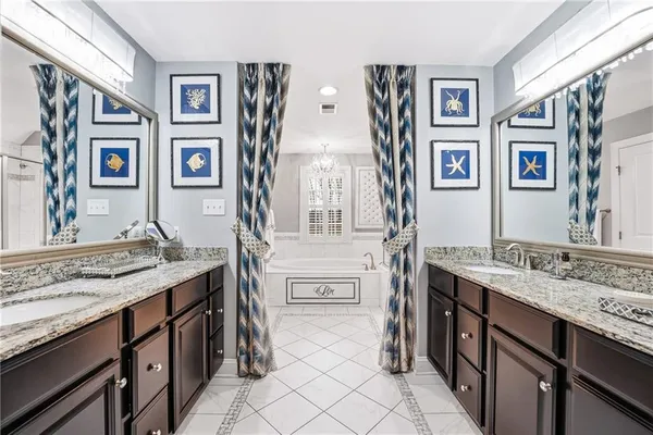 a spacious bathroom with a granite countertop double vanity sink and a window