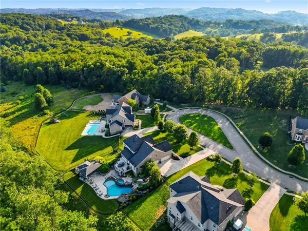 an aerial view of a house with a garden and lake view