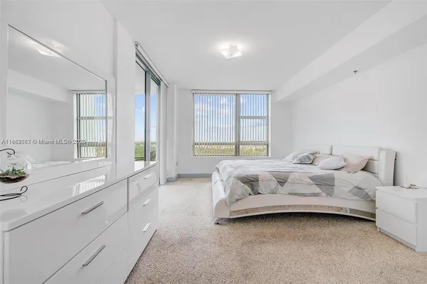 a bedroom with bed couch and window