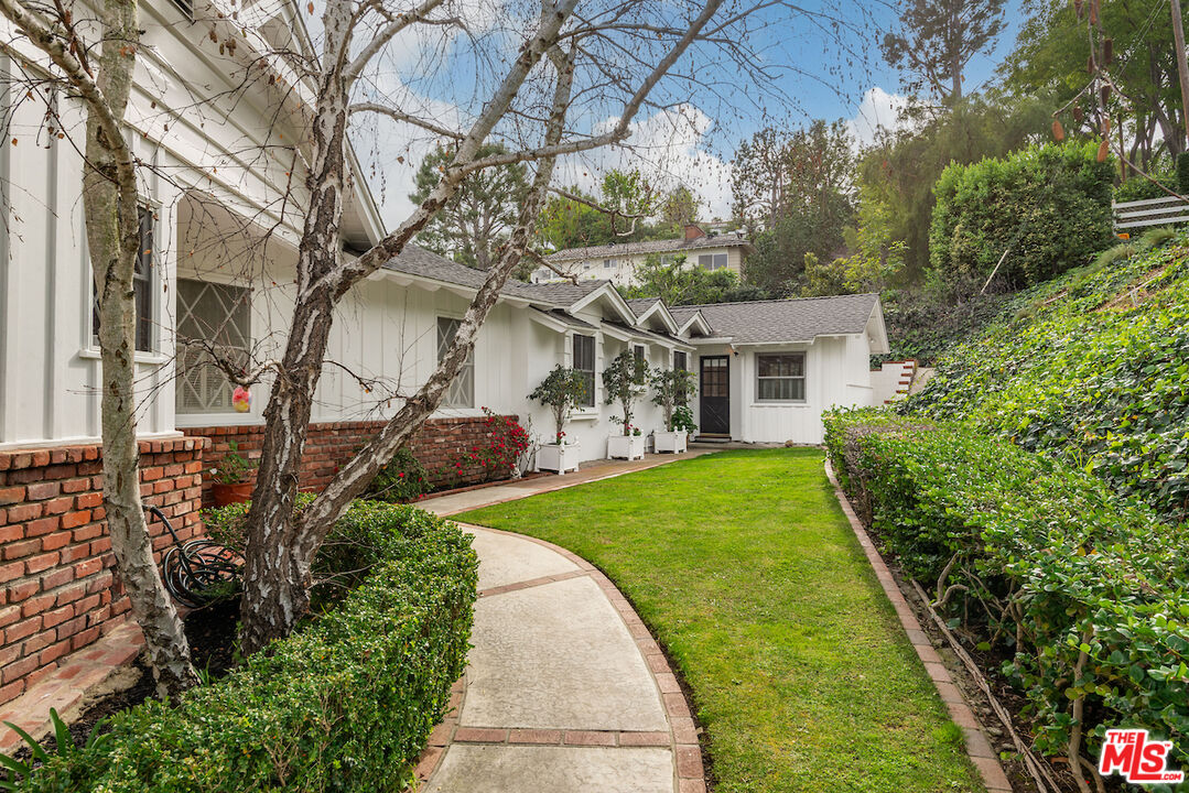 27280 Eastvale Road Palos Verdes Peninsula, CA 90274 - Photo 29 of 34 a view of a white house next to a yard with potted plants and large trees