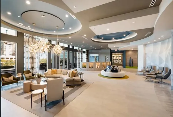 a large living room with stainless steel appliances kitchen island granite countertop furniture and a large window