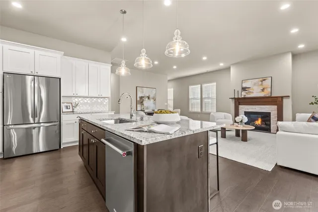 a kitchen with stainless steel appliances granite countertop a stove refrigerator and a fireplace
