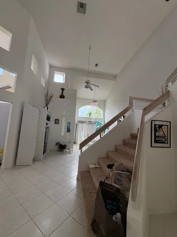 a view of a hallway with stairs and a living room