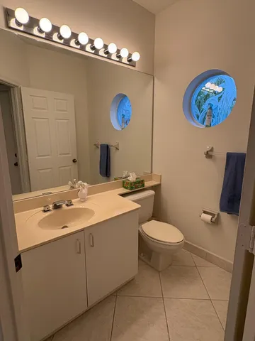 a bathroom with a toilet a sink and mirror