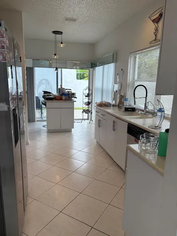 a kitchen with stainless steel appliances a sink a stove a refrigerator and cabinets