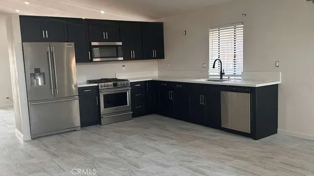 a kitchen with stainless steel appliances granite countertop a stove a refrigerator and a sink