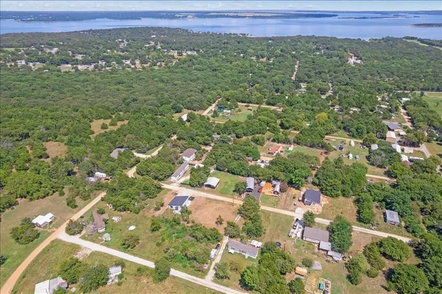 an aerial view of residential houses with outdoor space and trees