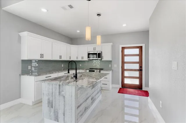 a kitchen with stainless steel appliances granite countertop a sink and cabinets