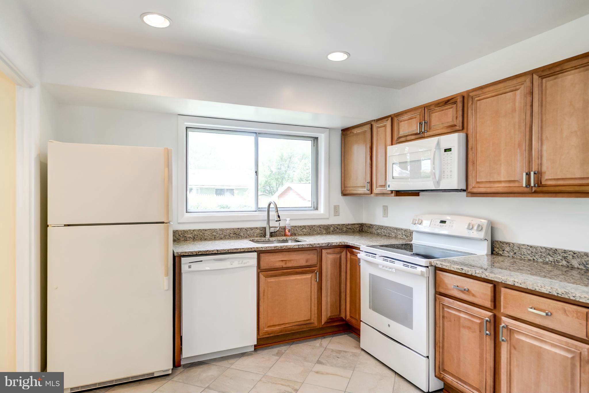 3918 Elby Street Silver Spring, MD 20906 - Photo 4 of 23 a kitchen with white cabinets and white appliances