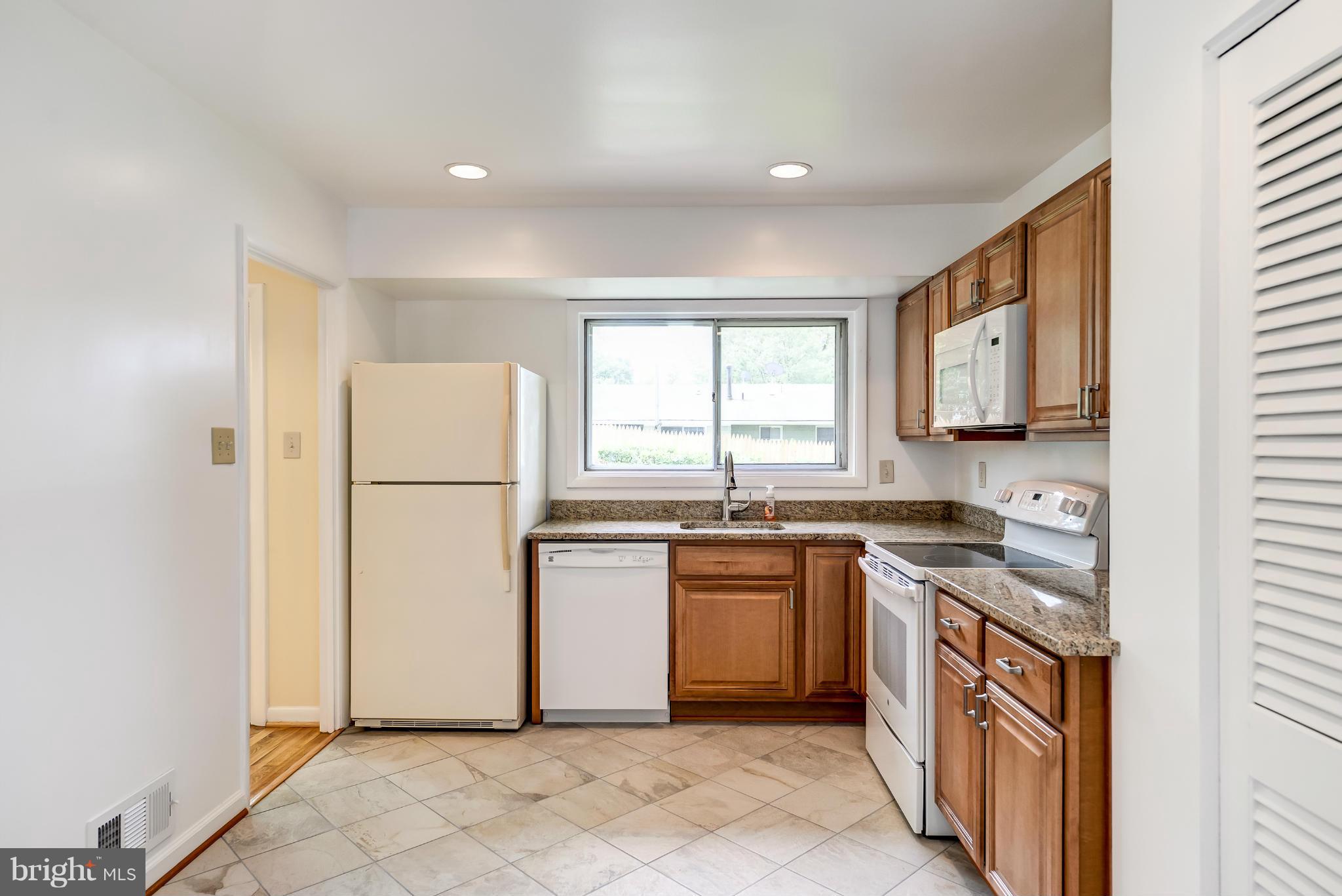 3918 Elby Street Silver Spring, MD 20906 - Photo 5 of 23 a kitchen with stainless steel appliances granite countertop a refrigerator a sink a stove a microwave a counter space and cabinets