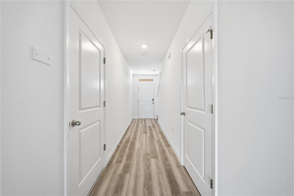 2480 Riversong Ldg Lane Wesley Chapel, FL 33543 - Photo 13 of 30 a view of a hallway with wooden floor and a bathroom