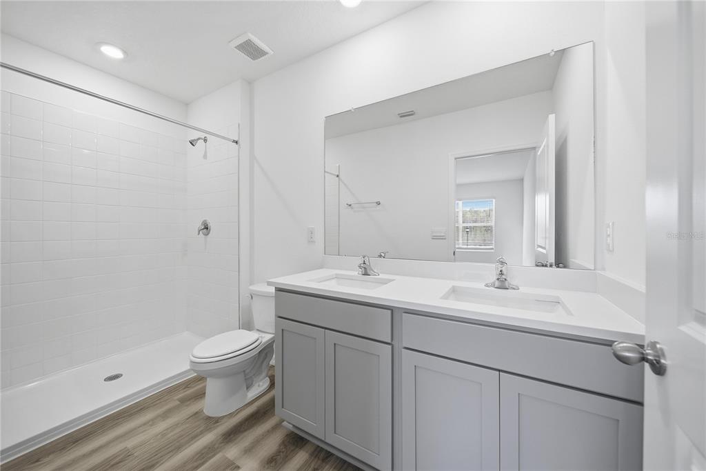 2480 Riversong Ldg Lane Wesley Chapel, FL 33543 - Photo 17 of 30 a bathroom with a toilet sink and mirror