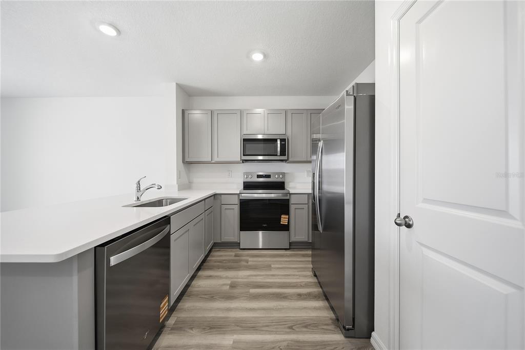 2480 Riversong Ldg Lane Wesley Chapel, FL 33543 - Photo 6 of 30 a kitchen with stainless steel appliances a refrigerator sink and white stove