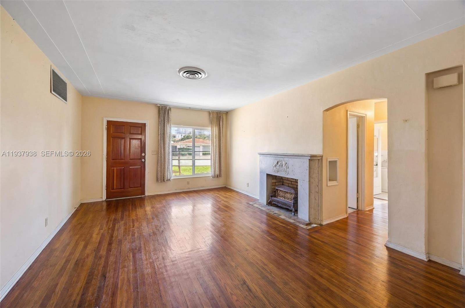 9148 Abbott Avenue Surfside, FL 33154 - Photo 13 of 39 an empty room with wooden floor fireplace and windows