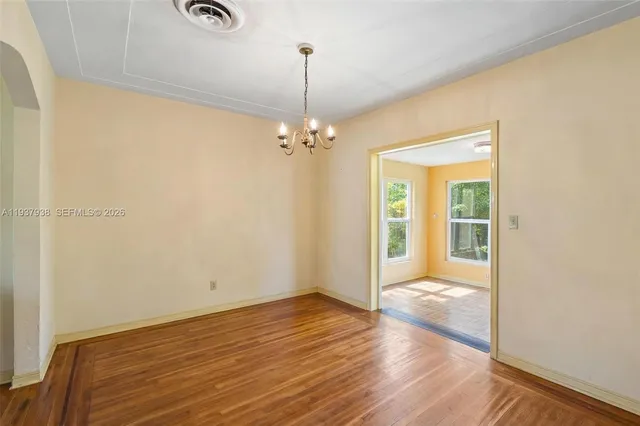 a view of a room with wooden floor fan and windows