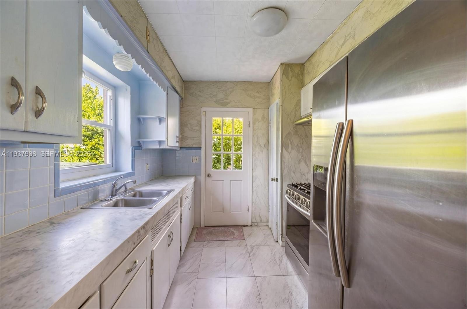 9148 Abbott Avenue Surfside, FL 33154 - Photo 19 of 37 a kitchen with a refrigerator and a sink