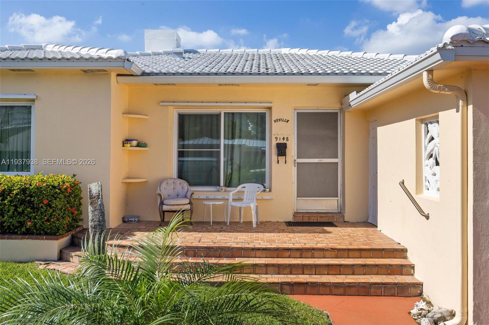 9148 Abbott Avenue Surfside, FL 33154 - Photo 3 of 39 a front view of a house with a garden