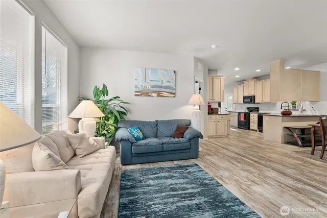 a living room with furniture and a dining table with kitchen view