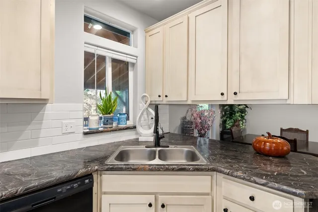 a kitchen with granite countertop white cabinets and a sink