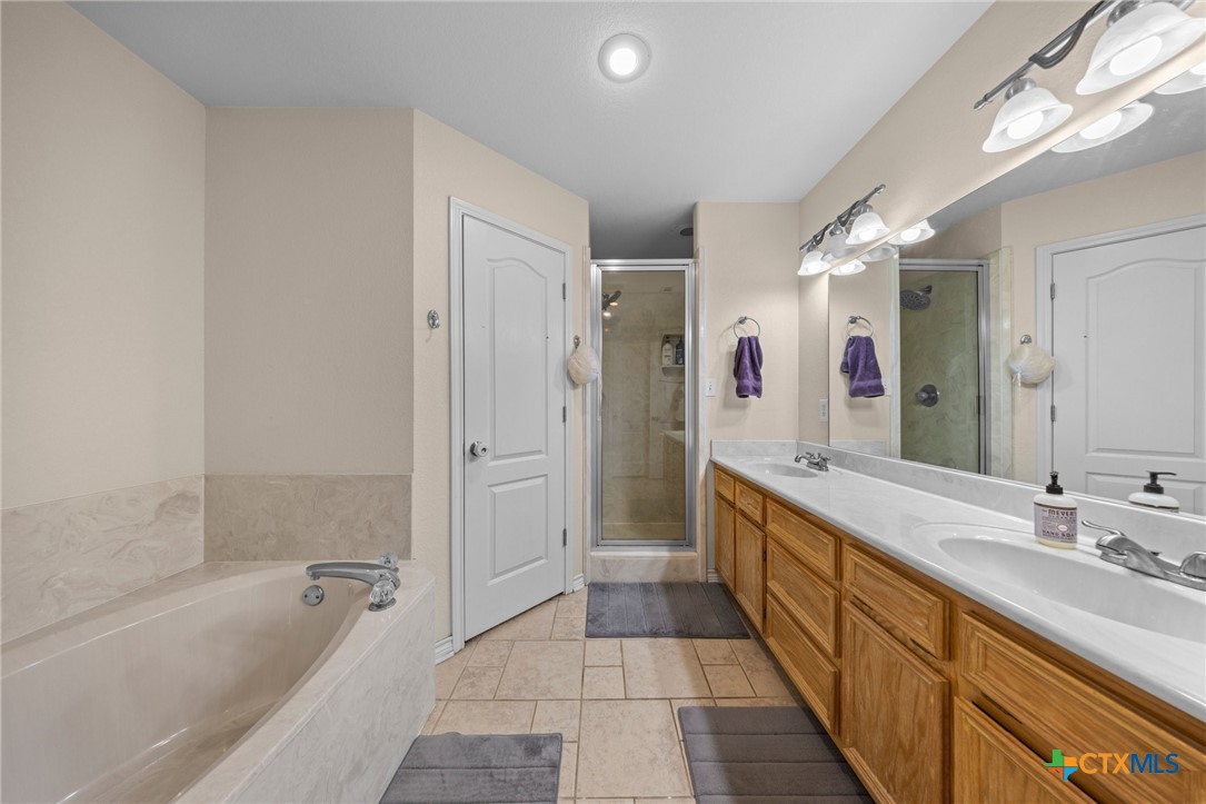 108 Gehler Circle Nolanville, TX 76559 - Photo 18 of 27 a bathroom with a granite countertop sink a mirror a bathtub and shower