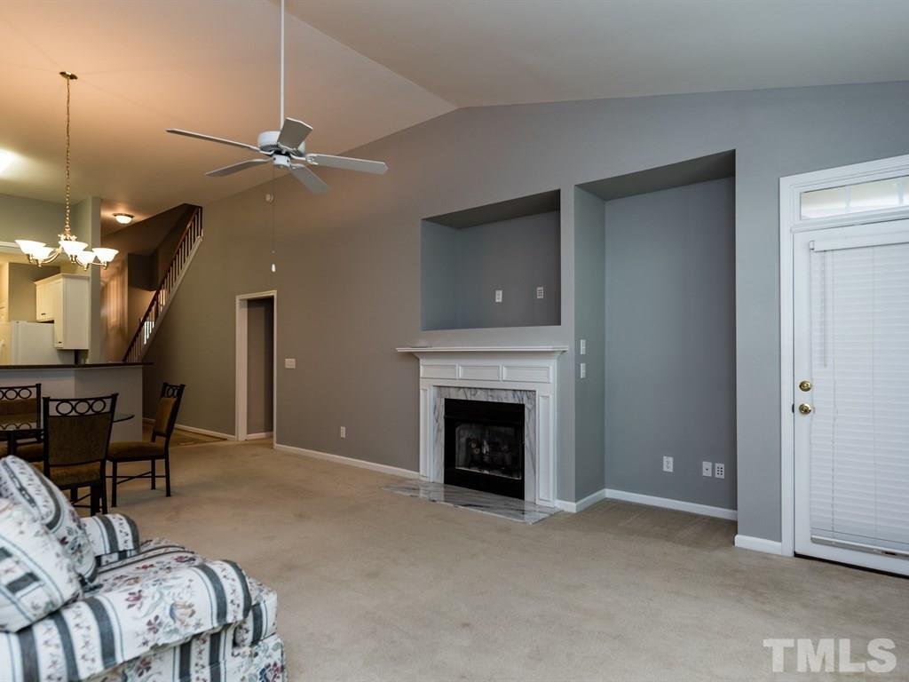 10483 Dapping Drive Raleigh, NC 27614 - Photo 7 of 21 a living room with furniture a fireplace and a chandelier