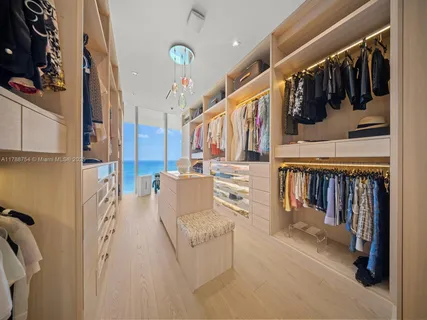 a view of walk in closet with clothes and shoes