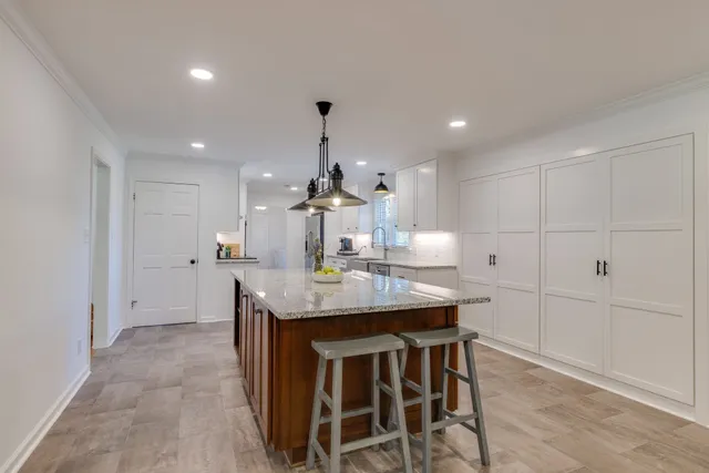 a kitchen with granite countertop kitchen island and stainless steel appliances