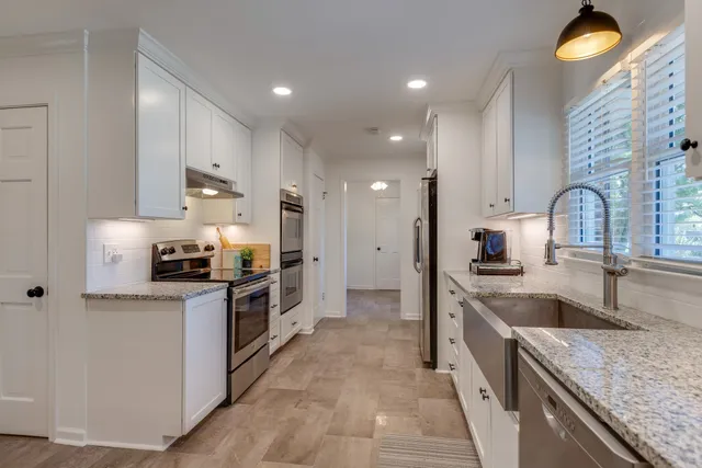 a kitchen with stainless steel appliances granite countertop a sink stove and refrigerator