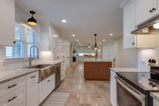 a large kitchen with stainless steel appliances lots of counter space and a sink