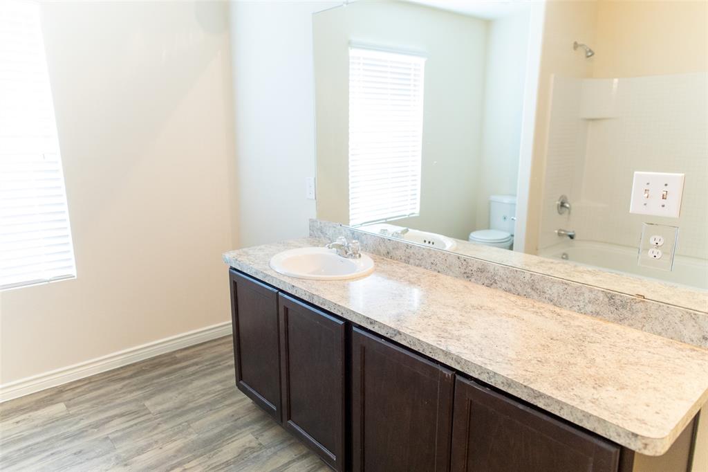 3526 Apple Valley Way Dallas, TX 75227 - Photo 10 of 13 a bathroom with a granite countertop sink and a mirror