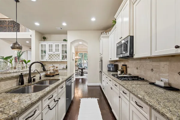 a kitchen with stainless steel appliances granite countertop a sink stove and cabinets