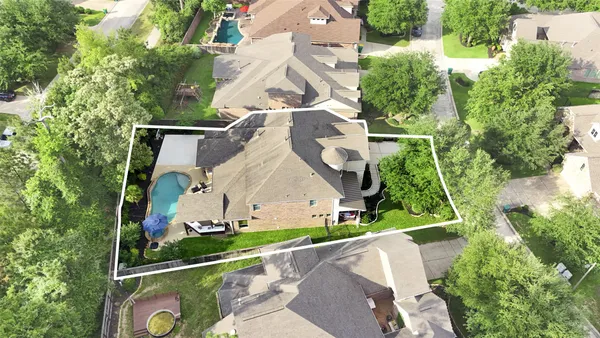 an aerial view of a house with a yard and potted plants