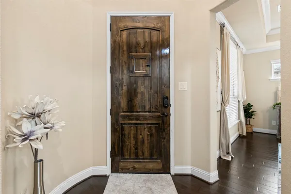 a view of a hallway with wooden floor and a livingroom