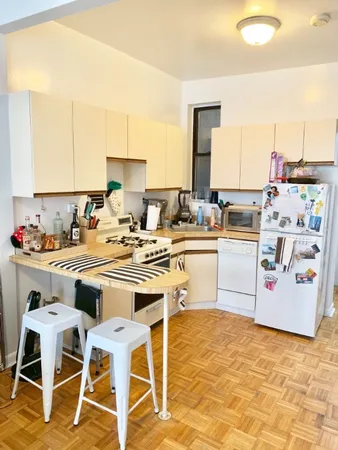 a kitchen with a stove top oven a sink a dining table and chairs